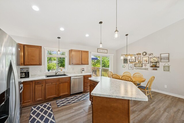 13362 Jefferson St, Becker, MN 55308 - kitchen featuring stainless steel appliances, a sink, wood finished floors, a center island, and decorative backsplash