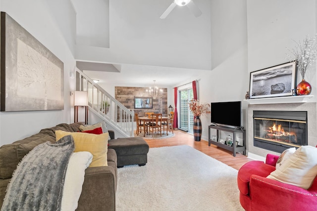 8345 Corcoran Cir Unit 42, Inver Grove Heights, MN 55076 - living room featuring a high ceiling, a chandelier, wood finished floors, stairway, and a glass covered fireplace