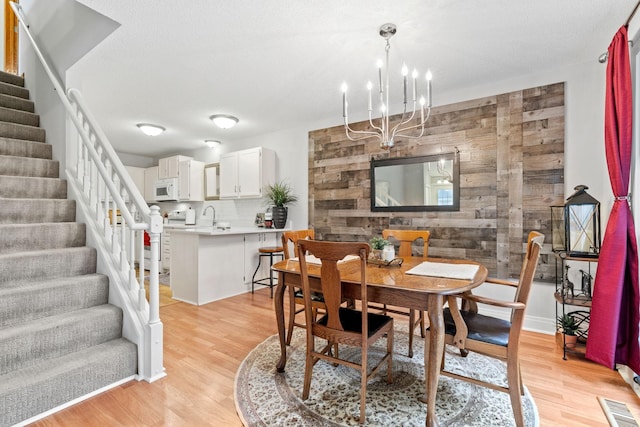 8345 Corcoran Cir Unit 42, Inver Grove Heights, MN 55076 - dining space featuring stairway, a chandelier, light wood-style floors, and wood walls