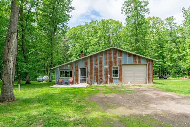 19214 County Road 12, Irondale Twp, MN 56455 - view of front facade featuring a chimney, dirt driveway, a front yard, and a detached garage