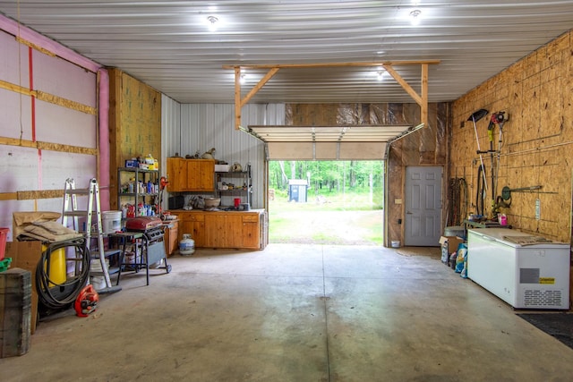 19214 County Road 12, Irondale Twp, MN 56455 - garage with refrigerator and a workshop area