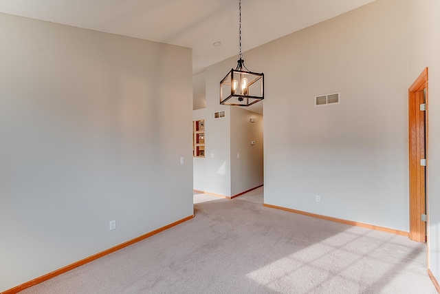 7539 Derby Ln, Shakopee, MN 55379 - unfurnished room with light colored carpet, a high ceiling, baseboards, and a chandelier