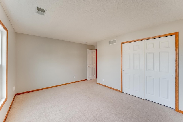 7539 Derby Ln, Shakopee, MN 55379 - unfurnished bedroom with light carpet, baseboards, a closet, and a textured ceiling