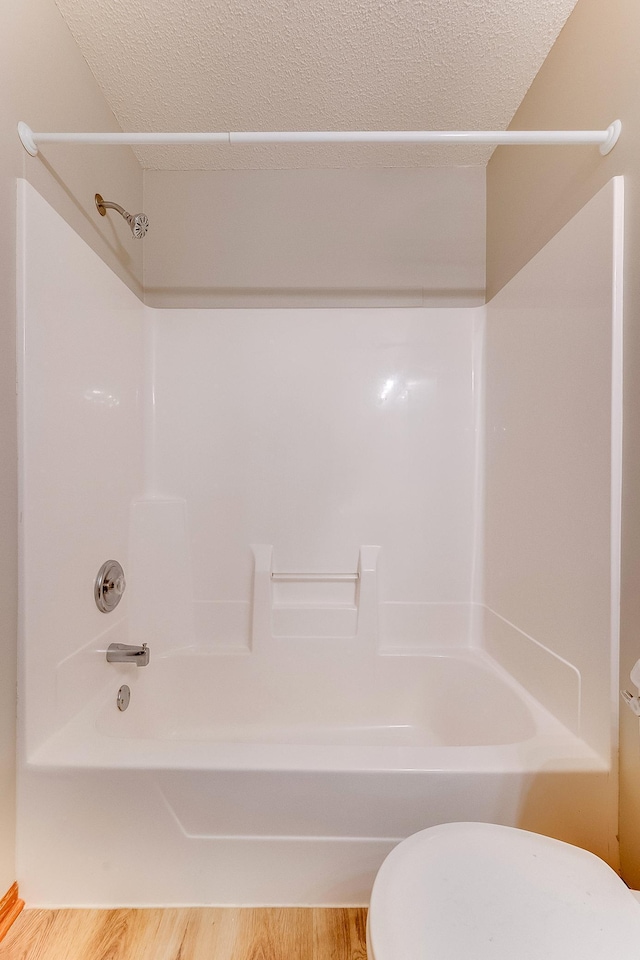 7539 Derby Ln, Shakopee, MN 55379 - bathroom featuring toilet, shower / bath combination, wood finished floors, and a textured ceiling