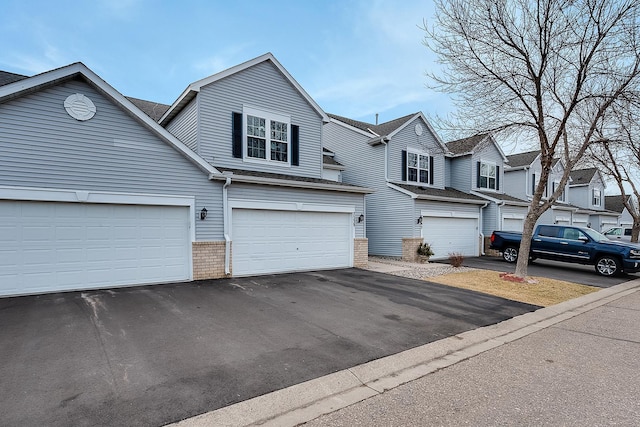 7539 Derby Ln, Shakopee, MN 55379 - townhome / multi-family property with brick siding, asphalt driveway, and an attached garage
