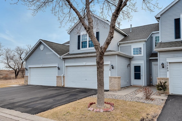 7539 Derby Ln, Shakopee, MN 55379 - traditional-style house with driveway, roof with shingles, a garage, and brick siding