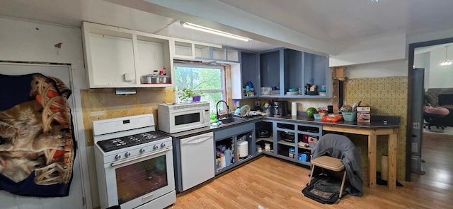 17548 749th Ave, Albert Lea Twp, MN 56007 - kitchen featuring white appliances, a sink, light wood finished floors, and backsplash