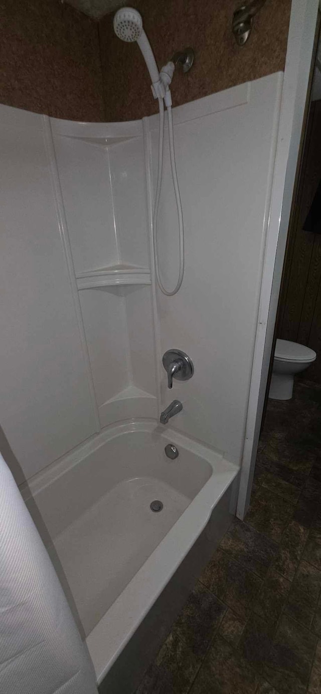 17548 749th Ave, Albert Lea Twp, MN 56007 - bathroom with shower / washtub combination, toilet, and stone finish floors