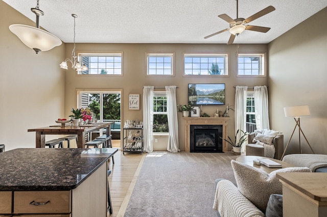 7147 153rd Ter, Savage, MN 55378 - living area with a textured ceiling, healthy amount of natural light, a ceiling fan, a chandelier, and a glass covered fireplace