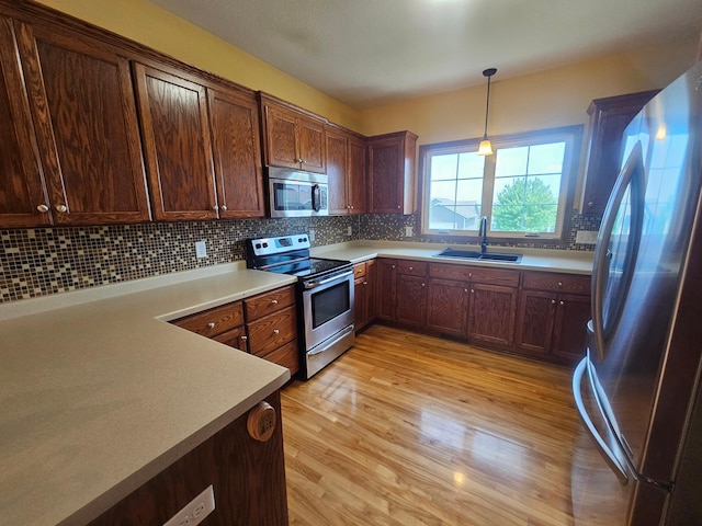 3657 46th Ave NW, Rochester, MN 55901 - kitchen with appliances with stainless steel finishes, a sink, light wood-type flooring, and decorative backsplash