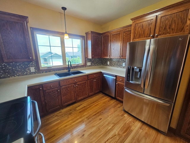 3657 46th Ave NW, Rochester, MN 55901 - kitchen featuring appliances with stainless steel finishes, a sink, light wood-style flooring, light countertops, and backsplash