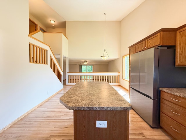 3100 212th St W, Farmington, MN 55024 - kitchen featuring freestanding refrigerator, a kitchen island, brown cabinets, light wood-style floors, and a ceiling fan