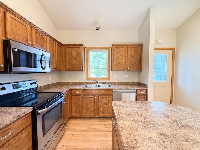 3100 212th St W, Farmington, MN 55024 - kitchen with stainless steel appliances, a sink, light wood-style floors, and brown cabinetry