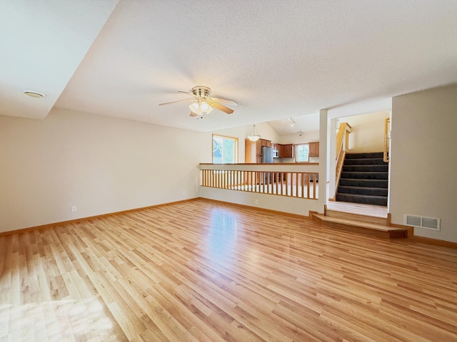 3100 212th St W, Farmington, MN 55024 - unfurnished room with light wood-style floors, a ceiling fan, stairs, and baseboards
