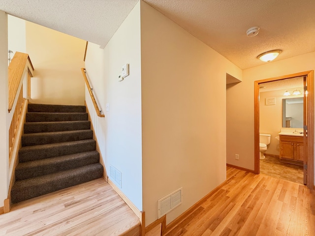 3100 212th St W, Farmington, MN 55024 - staircase with a textured ceiling, wood finished floors, and baseboards