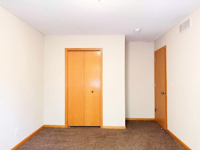 3100 212th St W, Farmington, MN 55024 - unfurnished bedroom featuring carpet, a textured ceiling, baseboards, and a closet