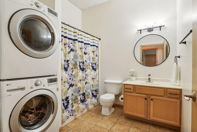3310 Nicollet Ave Unit 302, Minneapolis, MN 55408 - bathroom with stacked washing machine and dryer, toilet, vanity, tile patterned floors, and a shower with curtain
