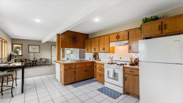 9803 287th Ave NW, Zimmerman, MN 55398 - kitchen featuring white appliances, under cabinet range hood, brown cabinetry, open floor plan, and recessed lighting