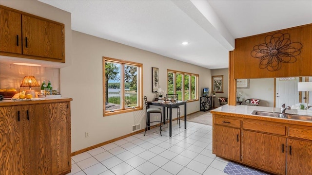 9803 287th Ave NW, Zimmerman, MN 55398 - kitchen with a sink, brown cabinets, baseboards, tile counters, and recessed lighting