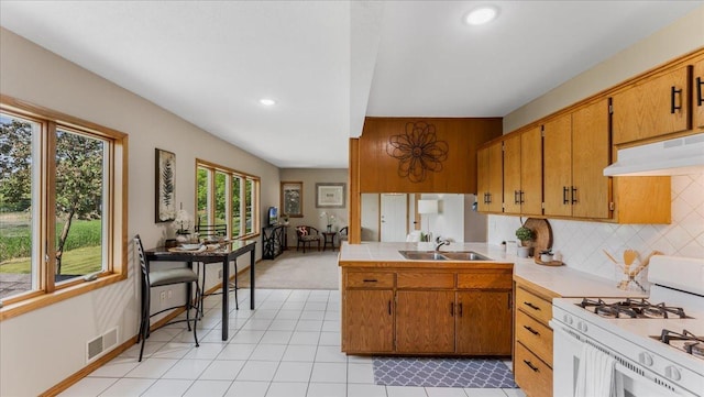 9803 287th Ave NW, Zimmerman, MN 55398 - kitchen featuring gas range gas stove, under cabinet range hood, brown cabinetry, a sink, and recessed lighting