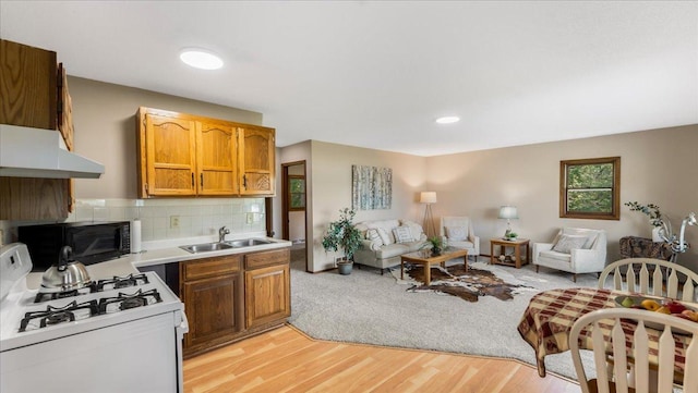 9803 287th Ave NW, Zimmerman, MN 55398 - kitchen featuring white gas range, black microwave, a sink, under cabinet range hood, and open floor plan
