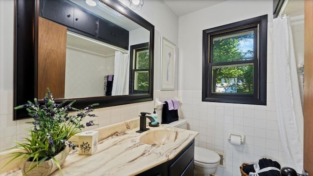 9803 287th Ave NW, Zimmerman, MN 55398 - full bath featuring toilet, vanity, tile walls, a shower with shower curtain, and a wainscoted wall