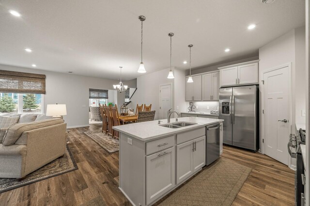 8738 Upper 9th Pl N, Lake Elmo, MN 55042 - kitchen with stainless steel appliances, open floor plan, a sink, a chandelier, and light countertops