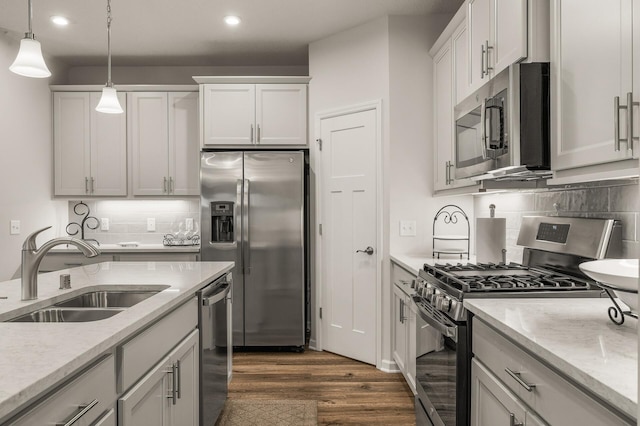 8738 Upper 9th Pl N, Lake Elmo, MN 55042 - kitchen with appliances with stainless steel finishes, a sink, dark wood-style flooring, recessed lighting, and decorative light fixtures