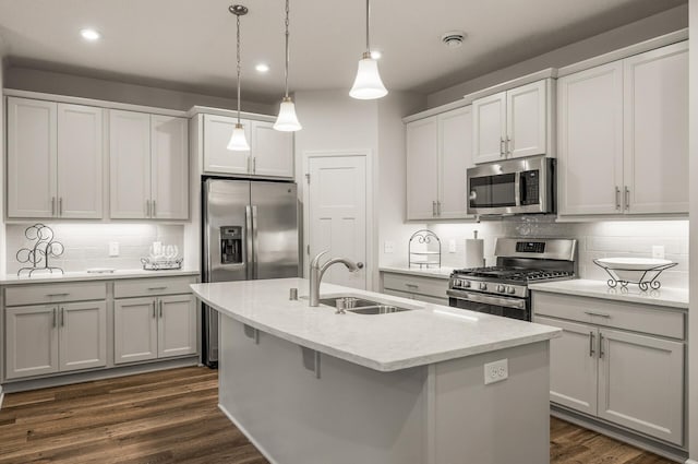 8738 Upper 9th Pl N, Lake Elmo, MN 55042 - kitchen featuring appliances with stainless steel finishes, a sink, tasteful backsplash, an island with sink, and hanging light fixtures