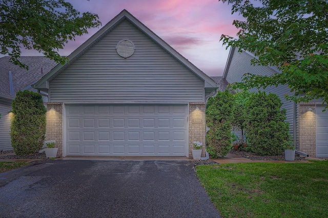 1584 126th Ln NW, Coon Rapids, MN 55448 - garage at dusk featuring driveway