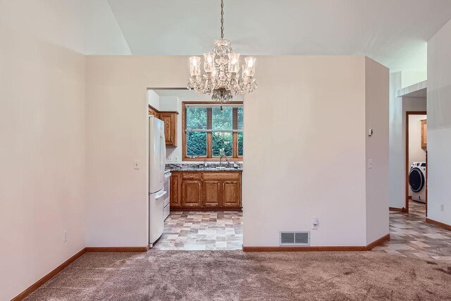 1584 126th Ln NW, Coon Rapids, MN 55448 - unfurnished dining area with washer / dryer, a chandelier, and light colored carpet