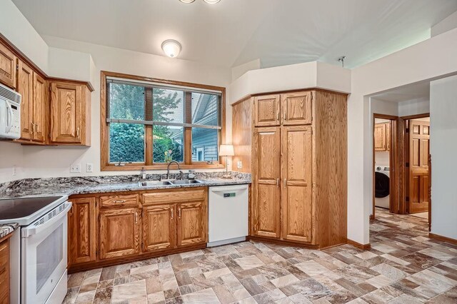 1584 126th Ln NW, Coon Rapids, MN 55448 - kitchen featuring white appliances, washer / clothes dryer, light stone countertops, and brown cabinets