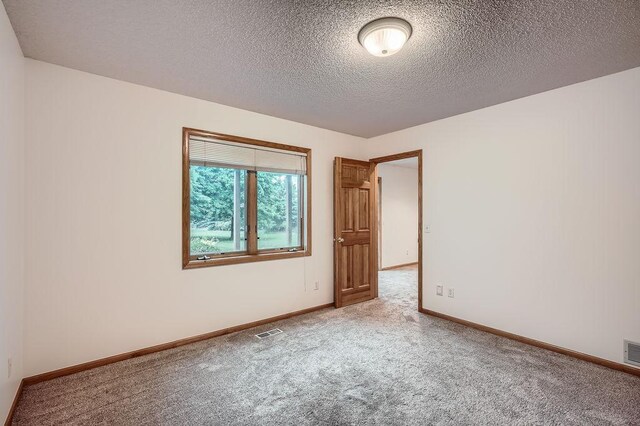 1584 126th Ln NW, Coon Rapids, MN 55448 - carpeted empty room with a textured ceiling and baseboards