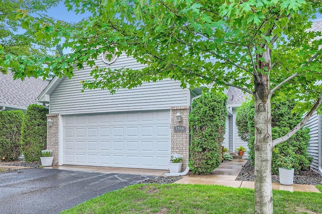 1584 126th Ln NW, Coon Rapids, MN 55448 - view of front of house featuring brick siding, asphalt driveway, and a garage