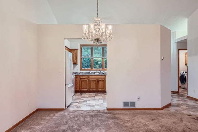 1584 126th Ln NW, Coon Rapids, MN 55448 - unfurnished dining area with washer / dryer, a chandelier, and light colored carpet