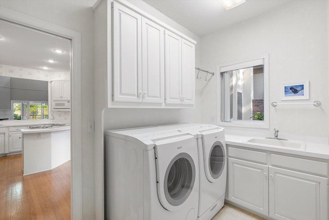 5555 70th St, Edina, MN 55439 - laundry area with washer and dryer, cabinet space, light wood-style floors, and recessed lighting