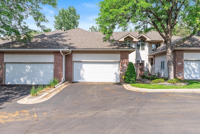 5555 70th St, Edina, MN 55439 - traditional-style home featuring brick siding, asphalt driveway, roof with shingles, and an attached garage