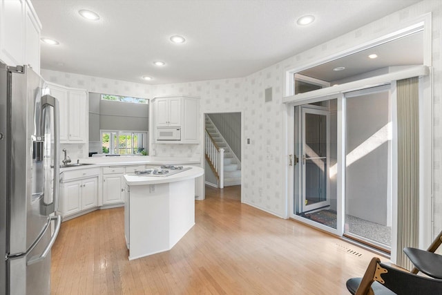 5555 70th St, Edina, MN 55439 - kitchen featuring white appliances, wallpapered walls, light countertops, a sink, and white cabinetry