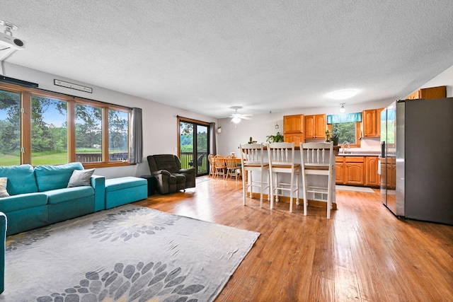 15607 93rd Cir NE, Otsego, MN 55330 - living area with a textured ceiling, light wood-style floors, and a ceiling fan