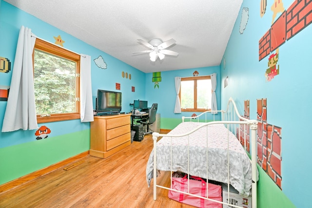 15607 93rd Cir NE, Otsego, MN 55330 - bedroom featuring multiple windows, a textured ceiling, wood finished floors, a desk, and baseboards