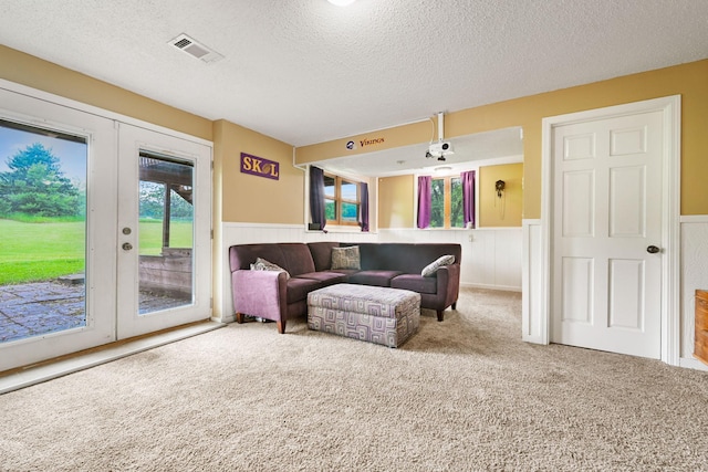 15607 93rd Cir NE, Otsego, MN 55330 - carpeted living room featuring french doors, a wainscoted wall, and a textured ceiling