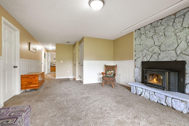 15607 93rd Cir NE, Otsego, MN 55330 - living area with a wainscoted wall, carpet, a textured ceiling, and a stone fireplace