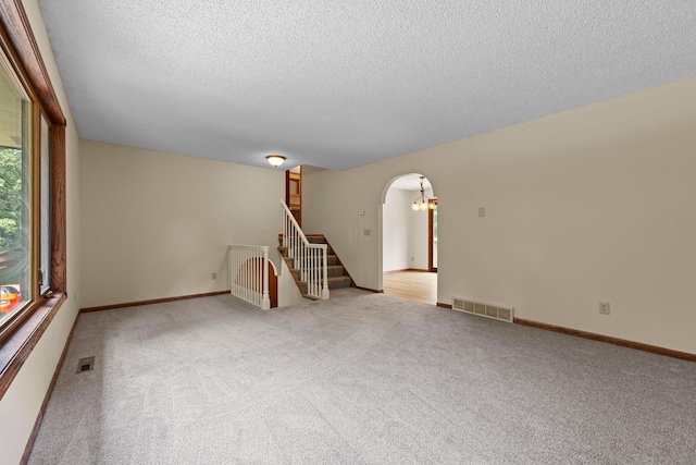 24345 165th St NW, Orrock Twp, MN 55309 - carpeted empty room with a textured ceiling, arched walkways, and stairway