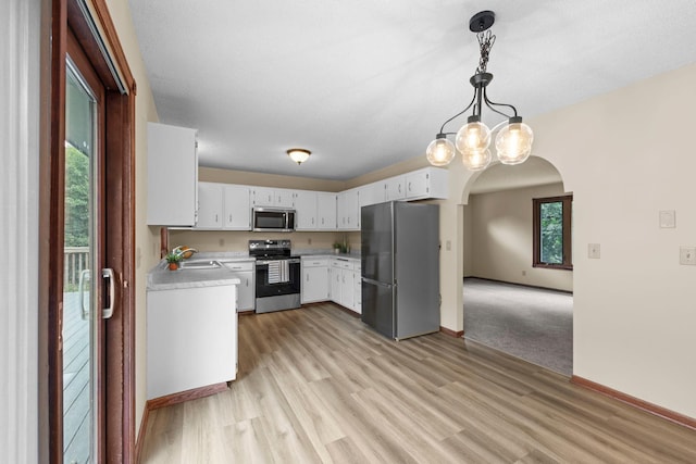 24345 165th St NW, Orrock Twp, MN 55309 - kitchen with appliances with stainless steel finishes, arched walkways, light countertops, light wood-type flooring, and pendant lighting