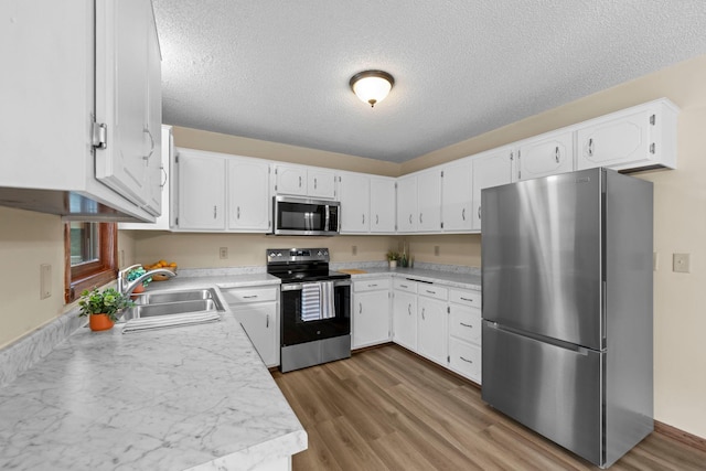 24345 165th St NW, Orrock Twp, MN 55309 - kitchen with appliances with stainless steel finishes, wood finished floors, a textured ceiling, white cabinets, and light countertops