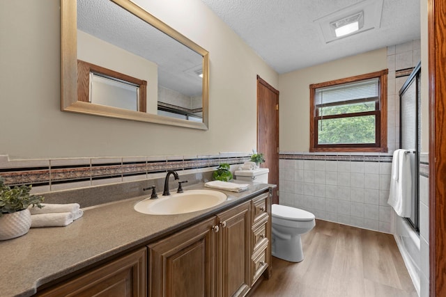 24345 165th St NW, Orrock Twp, MN 55309 - bathroom featuring tile walls, wood finished floors, vanity, a wainscoted wall, and a textured ceiling