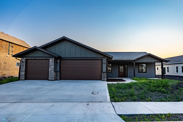 4712 Hampton Loop S, Moorhead, MN 56560 - view of front facade featuring an attached garage, concrete driveway, stone siding, board and batten siding, and a porch