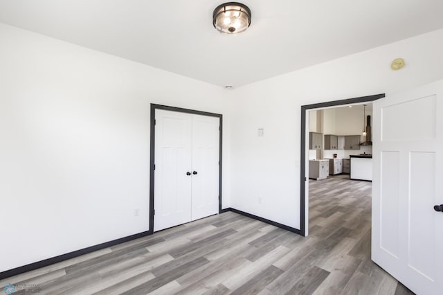 4712 Hampton Loop S, Moorhead, MN 56560 - unfurnished bedroom with light wood-style floors, baseboards, and a closet