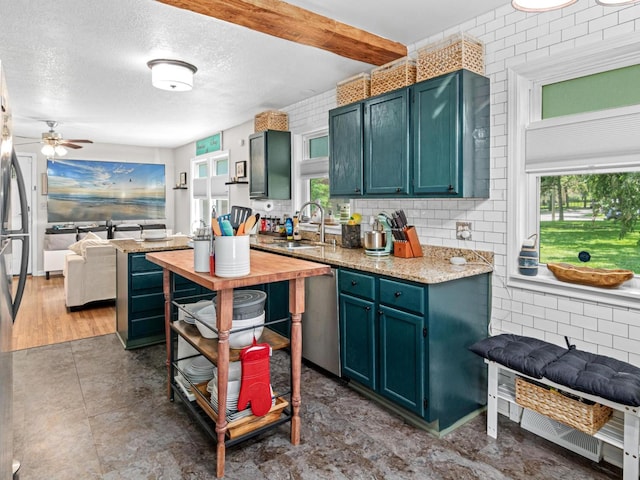 3944 Clinton Ave, Minneapolis, MN 55409 - kitchen with healthy amount of natural light, ceiling fan, stainless steel dishwasher, a textured ceiling, and open floor plan