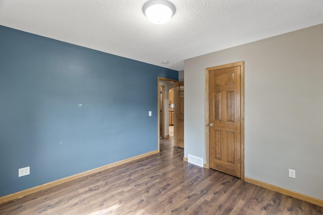 5107 Corvallis Ave N, Crystal, MN 55429 - spare room with wood finished floors, baseboards, and a textured ceiling